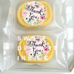 Roll of thank you stickers on clear packaging for yellow sweet dessert mooncakes