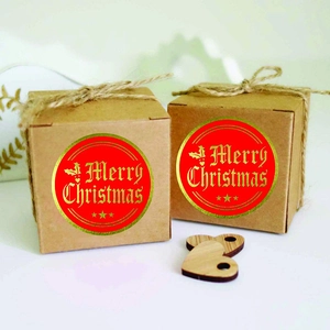 Brown kraft gift boxes with gold foil Merry Christmas stickers and rustic jute twine bows