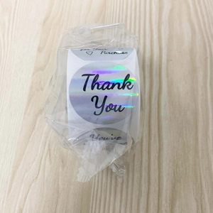 Macro detail of holographic rainbow Thank You stickers roll for business packaging decor