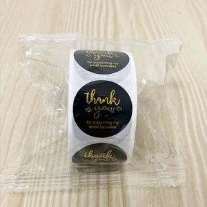Macro view of gold foil thank you stickers for small business in a roll packaging