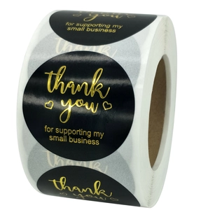 Macro detail of 1-inch black and gold foil Merry Christmas and Thank You roll stickers