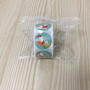 Detailed view of 500-count Christmas stickers roll with Santa Claus and gift box designs