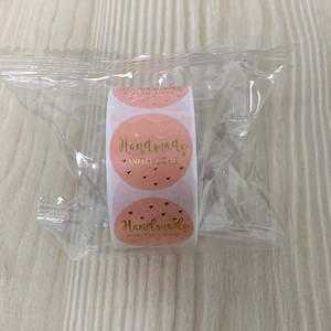 Detail showing 1 inch pink handmade with love stickers roll in gold foil stamping