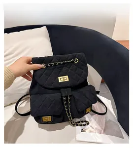 Macro shot of black quilted suede backpack with golden turn-lock and chain detail