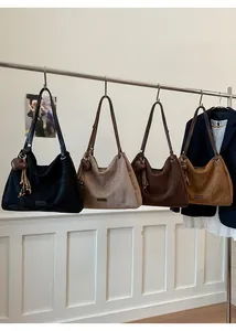 Row of four colorful large suede hobo bags with heart charms and fringe tassels