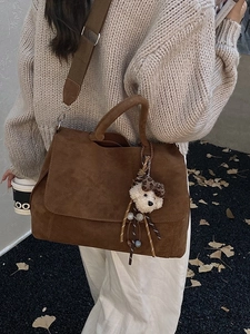 Borsa tote in camoscio marrone con ciondolo a orso e fiocco leopardato indossata