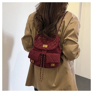 Detail of burgundy quilted suede mini backpack with gold twist lock and chain straps