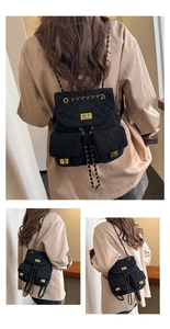 Detail view of the quilted velvet mini backpack showing chain straps and gold hardware