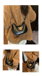 Détail du sac hobo noir avec chaîne dorée épaisse et fermoir rotatif métallique