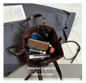 Internal view of the brown suede tote showing spacious compartments and zip pockets