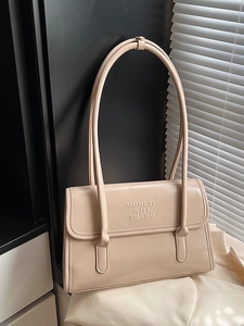 Sac à épaule minimaliste en cuir beige avec texte MUHETI gaufré sur fond élégant et épuré