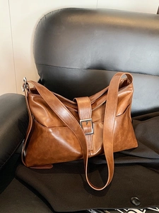 Brown vintage faux leather tote bag with wide strap and decorative metal buckle design