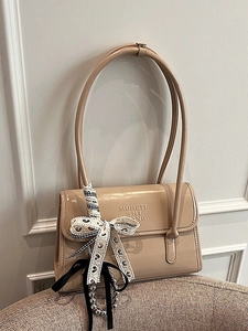 Sac bandoulière en cuir verni beige avec un nœud décoratif en dentelle bicolore