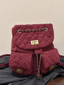 Quilted burgundy suede mini backpack with gold chain straps and turn-lock closure