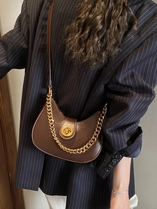 Sac hobo marron en demi-lune avec fermoir doré et chaîne sur blazer à rayures
