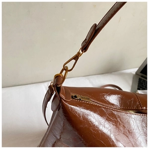 Detail of vintage brown tote featuring oil-wax leather texture and bronze lobster clasp