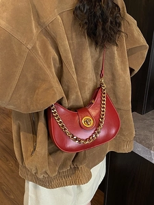 Sac bandoulière rouge en forme de demi-lune avec chaîne dorée et fermoir en métal