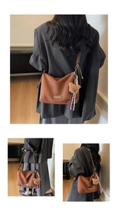 Détail du grand cabas marron mat avec charm ours en peluche et ruban rayé élégant