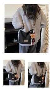 Détail du sac cabas en toile noire avec étiquette en cuir marron et breloque ours