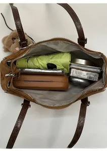Internal view of the brown suede bag showing storage for daily essentials like phone and umbrella