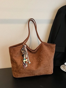 Braune Wildleder-Einkaufstasche mit goldenen Nieten und buntem Quasten-Anhänger
