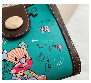 Close-up of green PU leather with bear graffiti, white stitching, and wood texture button