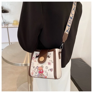 Detail of trendy graffiti crossbody bag with bear print and stylish wide canvas strap