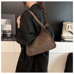 Detail of vintage brown tote with woven edge stitching and gold chain link strap accent
