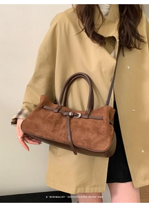 Mannequin portant un sac baguette en daim marron avec bride en cuir et boucle rétro