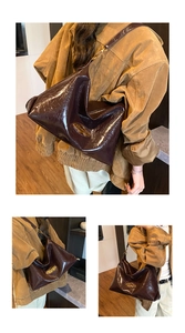 Detail of high-gloss patent leather shoulder bag with gold oval hardware and soft texture