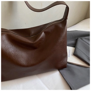 Detailed view of dark brown soft leather tote bag showing smooth texture and large capacity