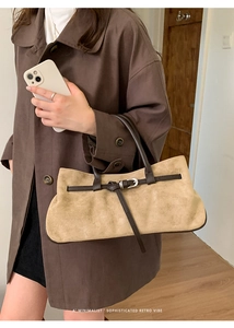 Détail du sac à bandoulière en daim avec sangle en cuir et boucle au style rétro minimaliste