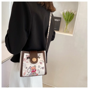 Detail of trendy crossbody bucket bag with bear graffiti and stylish wide strap