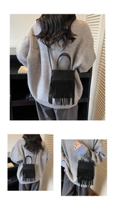 Détail d'un sac à bandoulière en cuir noir avec de longues franges et poignée ronde