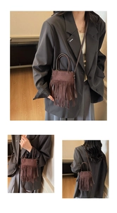 Détail d'un sac bandoulière en daim marron foncé avec franges rétro et lanière cuir