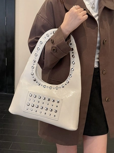 Schicke cremeweiße Hobo-Tasche mit silbernen Metallnieten und glänzendem Finish