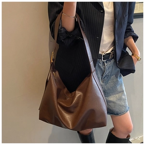 Brown soft leather tote bag with wide shoulder strap and spacious slouchy design