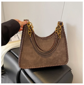 Detail of dark brown suede Hobo bag featuring woven leather edges and gold chain handle