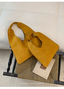 Macro view of mustard yellow suede tote bags in two sizes with a minimalist design
