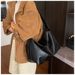 Side view of soft black faux leather hobo bag worn by model for daily commute style