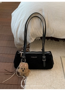Minimalist black baguette bag detail with silver lettering and cute teddy bear charm