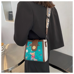 Detail of crossbody bag featuring cartoon bear graffiti and a stylish wide patterned strap