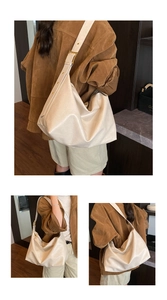 Detail of cream oversized tote bag showing wide strap and polished gold square buckle