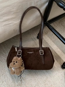 Coffee brown suede shoulder bag with bear charm and Fashion & Bags text on neutral background