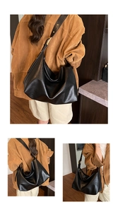 Close-up of black soft leather tote bag with elegant golden metal adjustment buckle