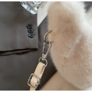 Détail du sac en fausse fourrure blanche avec bandoulière cuir et boucles argent
