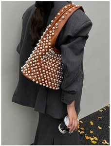 Braune Unterarmtasche mit weißen Perlen im herbstlichen Streetstyle-Look für Damen