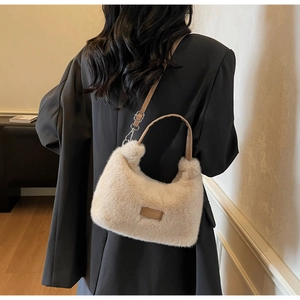 Détail du sac beige pelucheux montrant la texture douce et la bandoulière en cuir chic