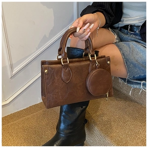 Detail of vintage dark brown faux leather handbag with matching round coin purse charm