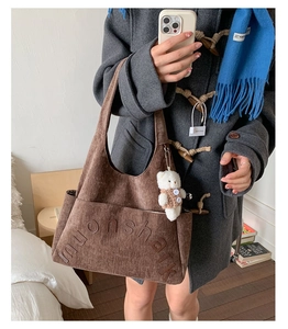 Détail du sac cabas en velours côtelé marron avec broderie et pendentif ours mignon
